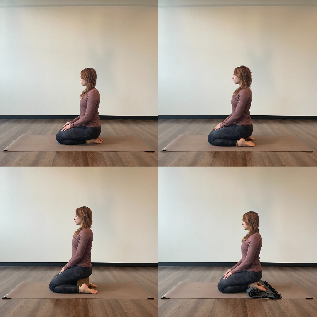 Marta Gruber, a white woman with red hair wearing black leggings and a dark red long sleeve shirt practices vajrasana on a beige yoga mat. 