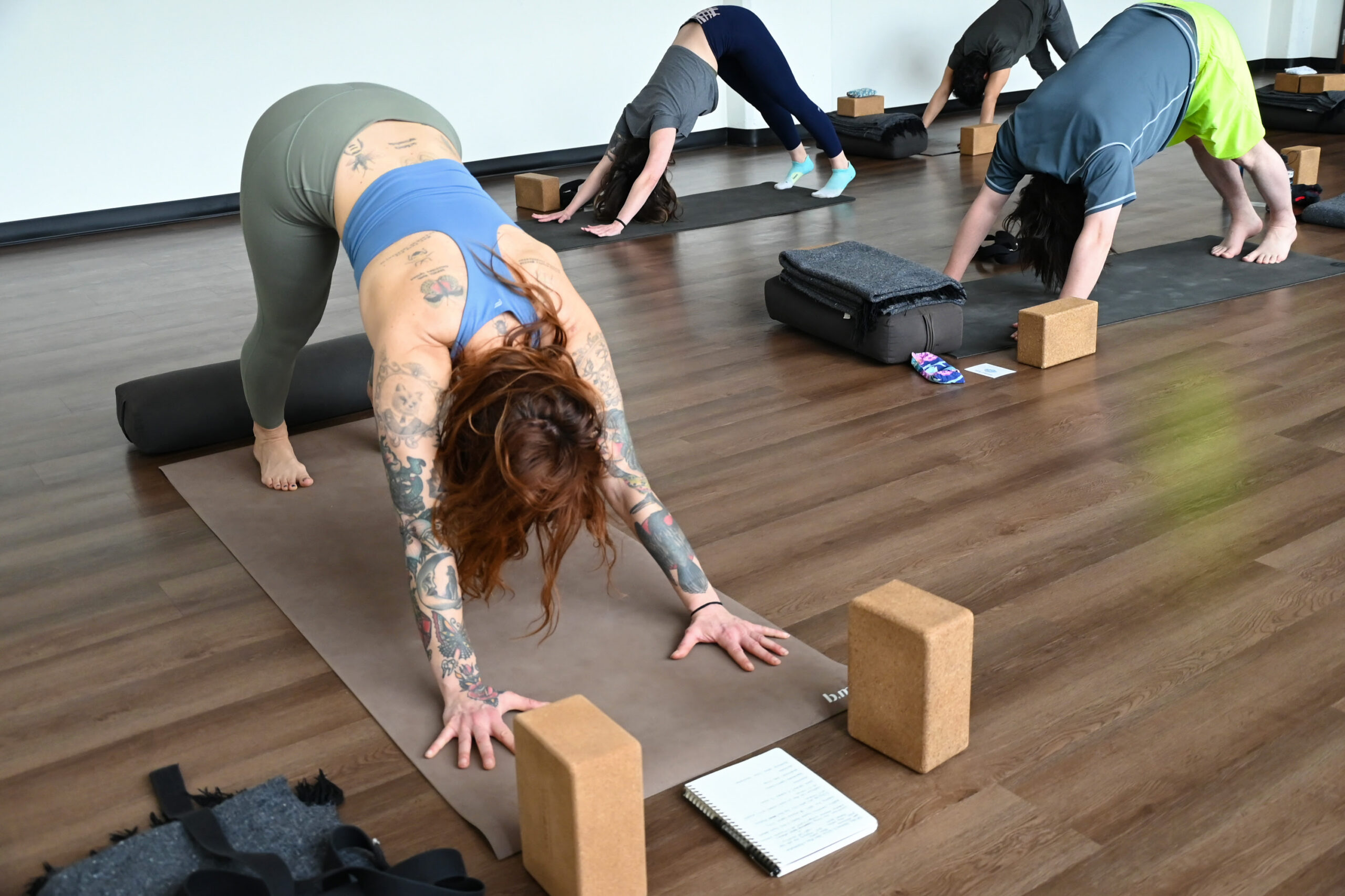 Marta Gruber leads a yoga class practicing downward facing dog.
